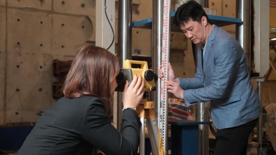 To build bridges to civil engineering knowledge related to social issues, Prof. Thomas Hu (right) took his students to different locations to measure the settlement levels.