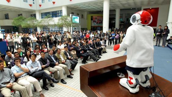 機 械 人 在 科 大 大 堂 向 觀 眾 講 話 。	