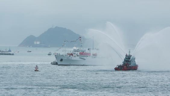 大洋一号在驶近海运大厦时，消防船施放水炮以表欢迎。	