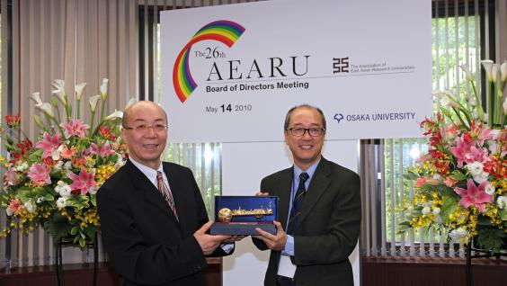 President Chan (right) presents to President Washida of Osaka University a golden key souvenir featuring Hong Kong’s landmarks, including the sundial at the HKUST entrance.	