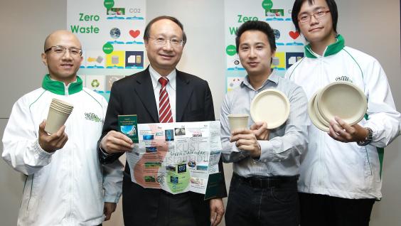 Prof Joseph Kwan (2nd from left) and Mr Calvin Kwan (2nd from right) and HKUST Green Ambassadors with an HKUST sustainability calendar, and cups and plates that can be composted	
