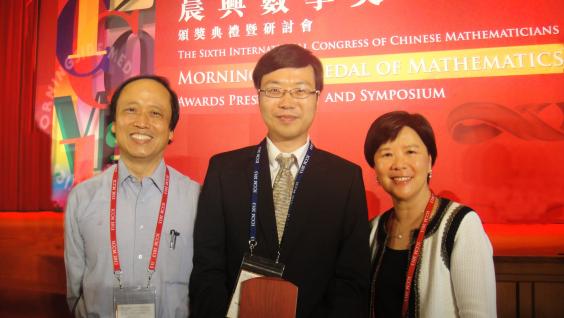  Prof Nancy Ip (right), Dean of Science and Prof Cheng Shiu-Yuen (left), Chair Professor of the Department of Mathematics congratulate Prof He Xuhua on receiving the Morningside Gold Medal of Mathematics.