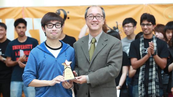 陳 繁 昌 校 長 頒 發 冠 軍 獎 座 給 表 演 節 奏 口 技 的 張 浩 漁 同 學 。	