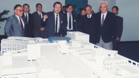  鍾博士（前左一）於1992年為到訪科大的時任國務院港澳辦公室主任魯平（前右一）介紹科大發展計劃。