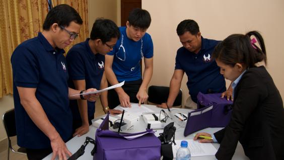  The student is demonstrating to the clinical staff in Cambodia how to use the mobile application of the electronic medical record system.